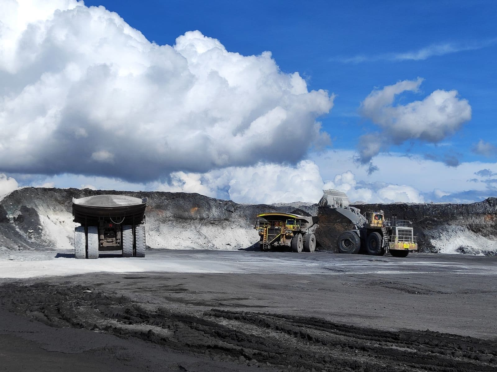 Haul trucks and excavators working in an open-pit mine
